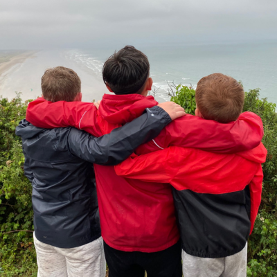 Three boys with their arms around each other's shoulders